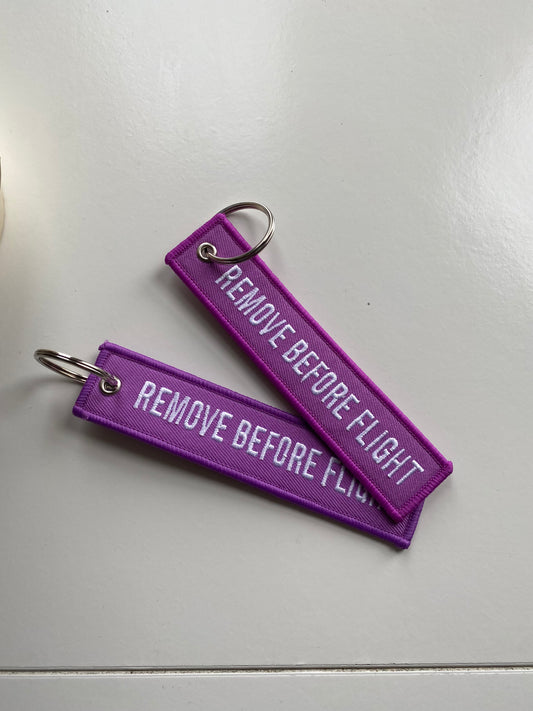 Purple remove before flight luggage tag